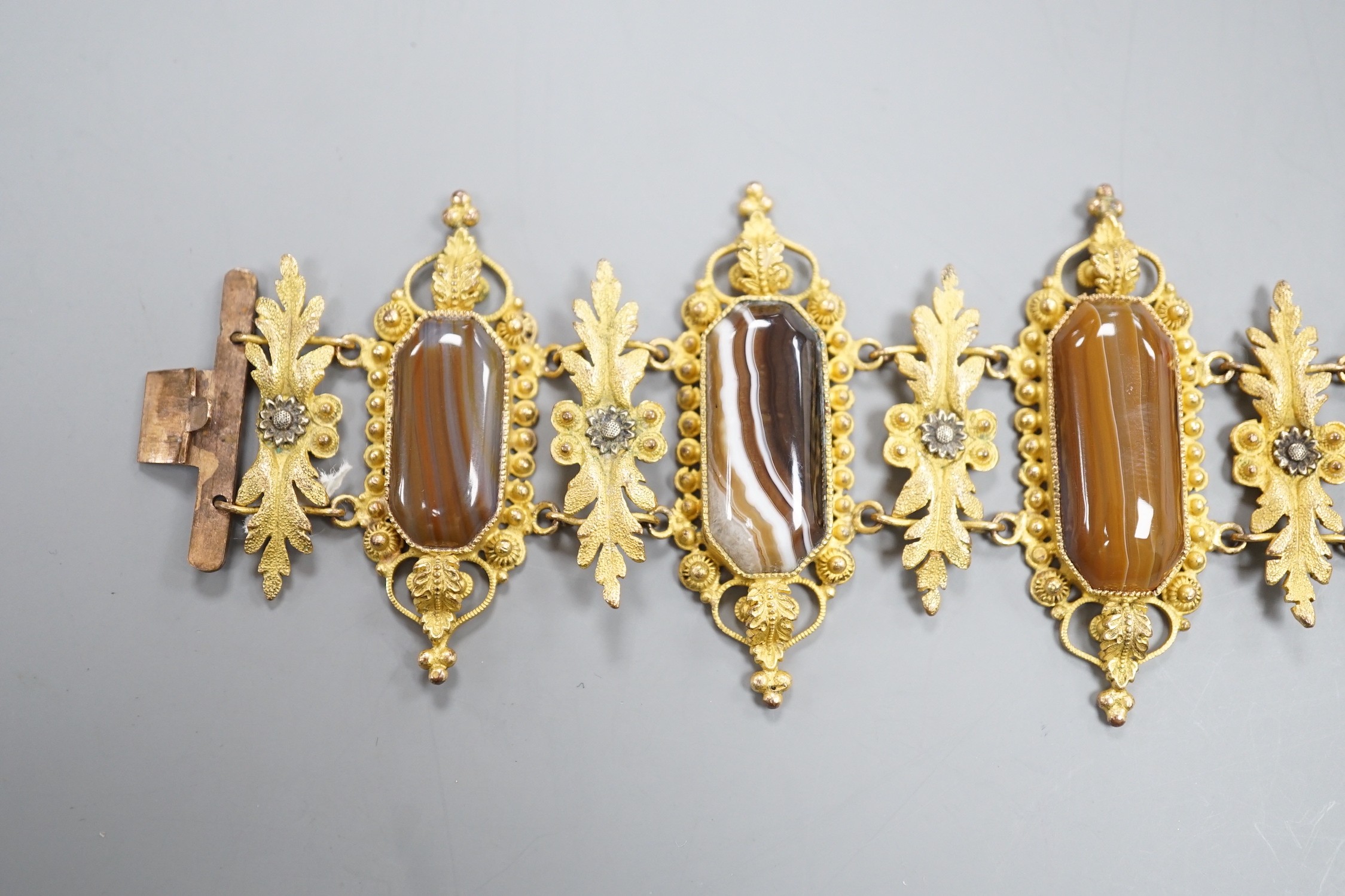 An ornate late Victorian pinchbeck and six stone banded agate set bracelet, 18.5cm.